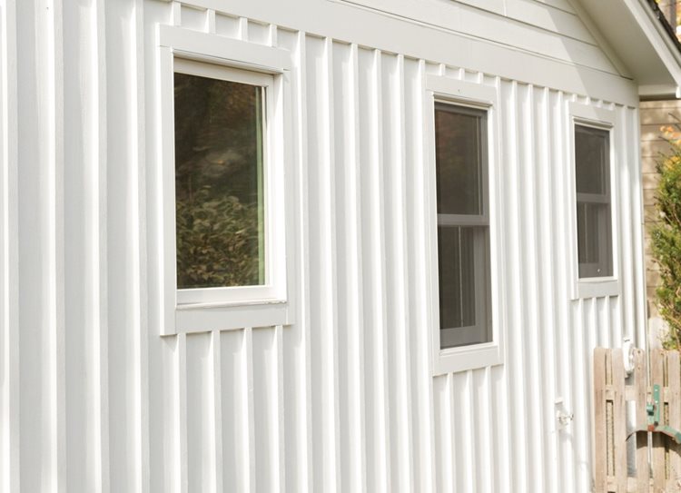 Building's exterior featuring vertical siding made up of long panels oriented vertically