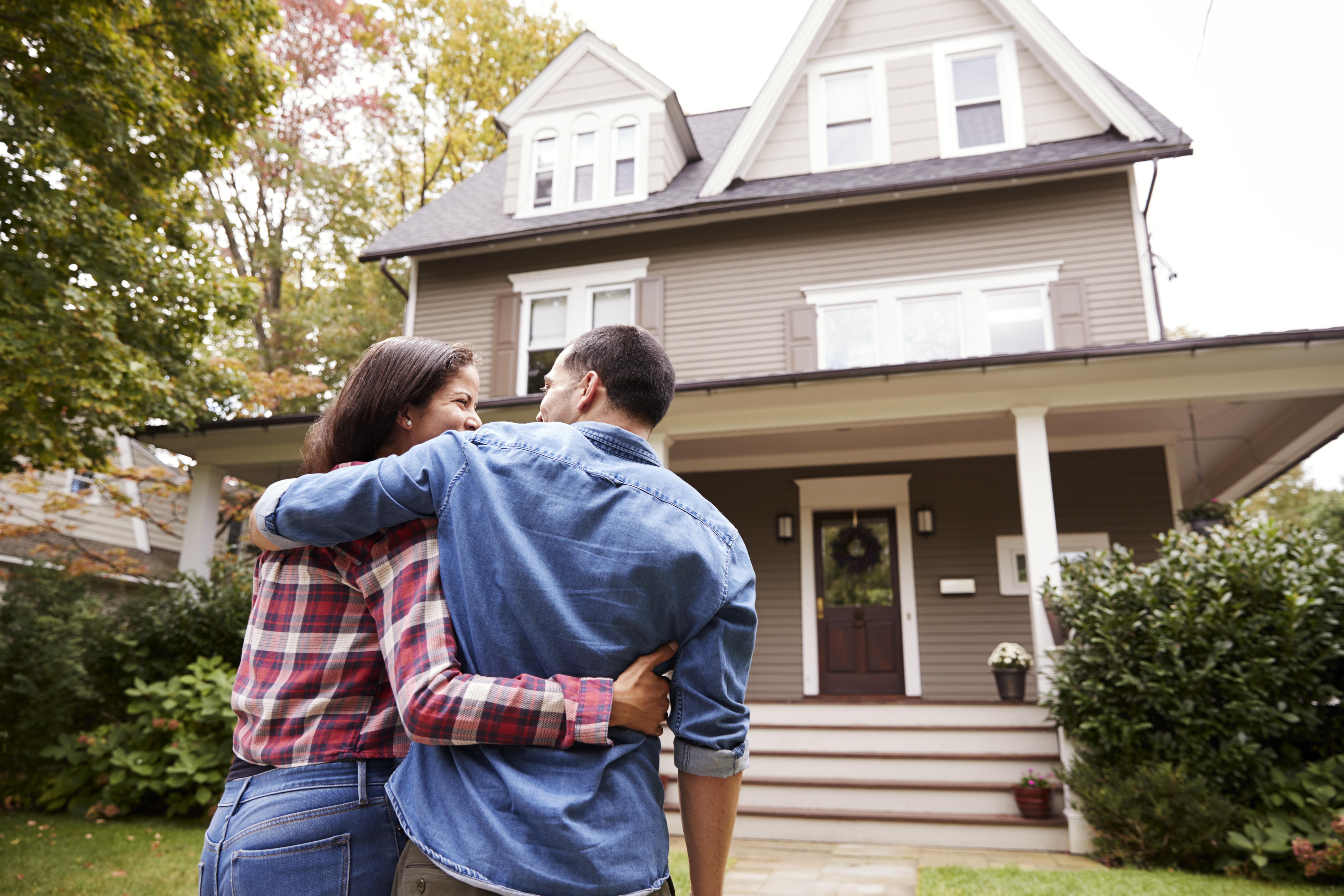 Homeowners Outside Their Home Looking at Siding Homeowners Outside Their Home Looking at Siding